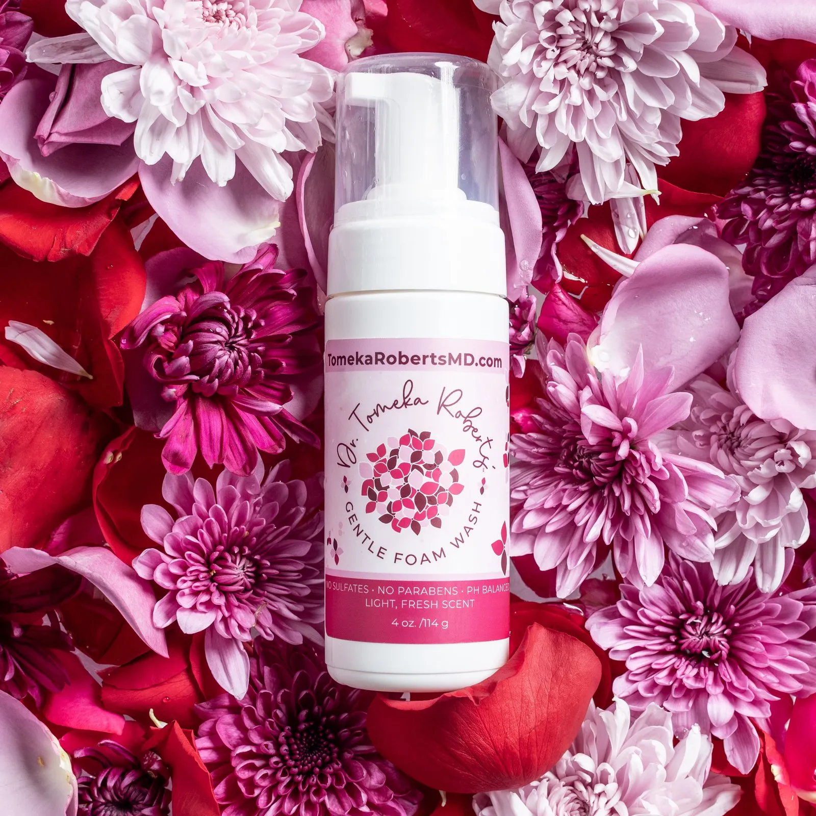 Fresh Scent Gentle Foam Wash resting on a bed of pink and crimson blooms